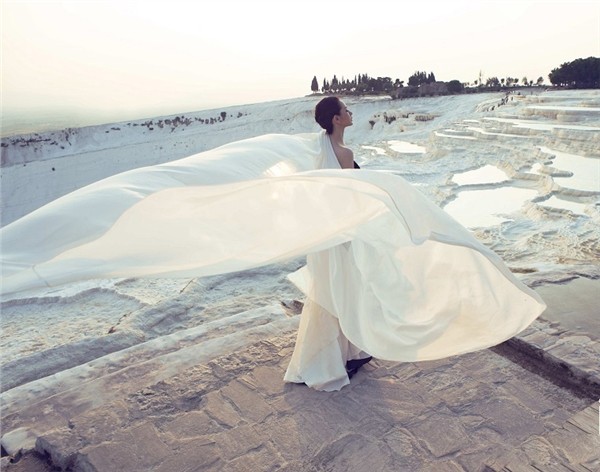 戚薇身着层叠白纱侧身回眸，轻盈面料随风微扬，眼神中流转着静谧与深邃