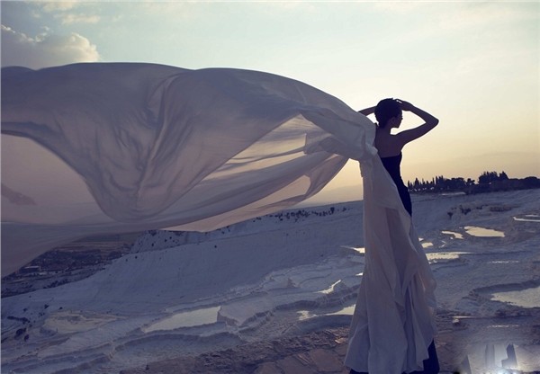 戚薇坐于光影交错处，白纱铺陈如云海，她目光澄澈望向远方似在凝思