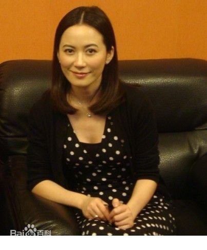 俞飞鸿身着优雅长裙静坐，姿态闲适，仿佛沉浸在自己的思绪世界里