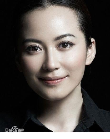 俞飞鸿倚靠桌旁，姿态放松，流露出自然不羁的随性与洒脱一面