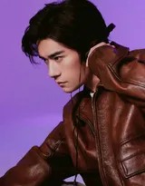 易烊千玺侧身倚靠墙面，黑色皮衣勾勒出肩线，随身听耳机线轻垂胸前，眼神中透出深邃复古感