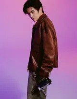 易烊千玺漫步街头，皮衣敞开随风轻扬，工装牛仔裤口袋细节凸显，随身听仿佛在播放怀旧旋律