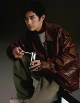 易烊千玺坐于台阶上，皮衣随意搭肩，工装牛仔裤褶皱自然，随身听耳机轻挂耳际，营造慵懒复古氛围