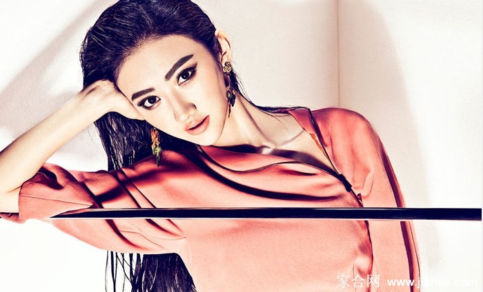 景甜手抚秀发展露明媚笑容，橘色光影在发丝与脸颊间跳跃嬉戏