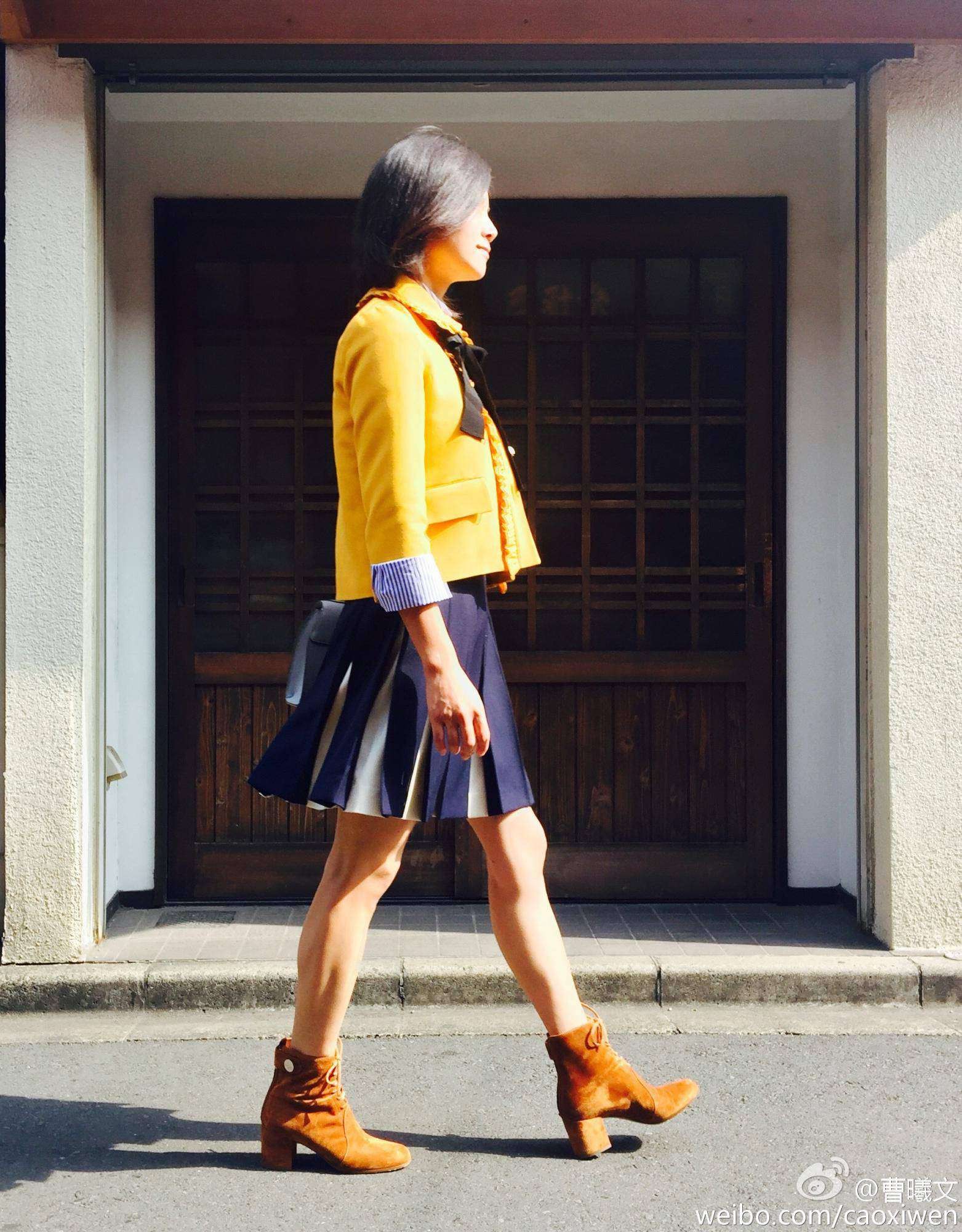 曹曦文坐在室内地板上，双腿随意屈起，低头浅笑，氛围轻松自在