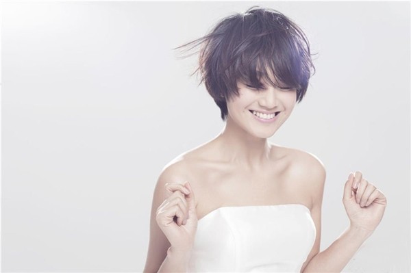 朱丹双手轻抚面颊闭目沉思，柔和光线勾勒出宁静而幸福的轮廓