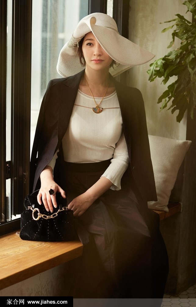 光影交错中李小冉身着黑色西装，眼神坚定而深邃，彰显现代女性的力量感