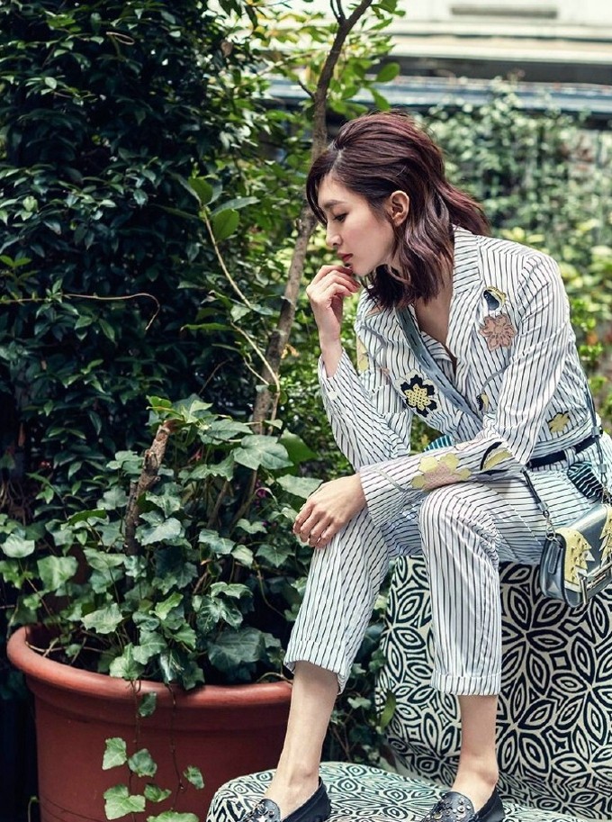 江疏影展露明媚笑颜，温暖笑意与周身绽放的刺绣花朵交织，散发出极具感染力的灵动生气