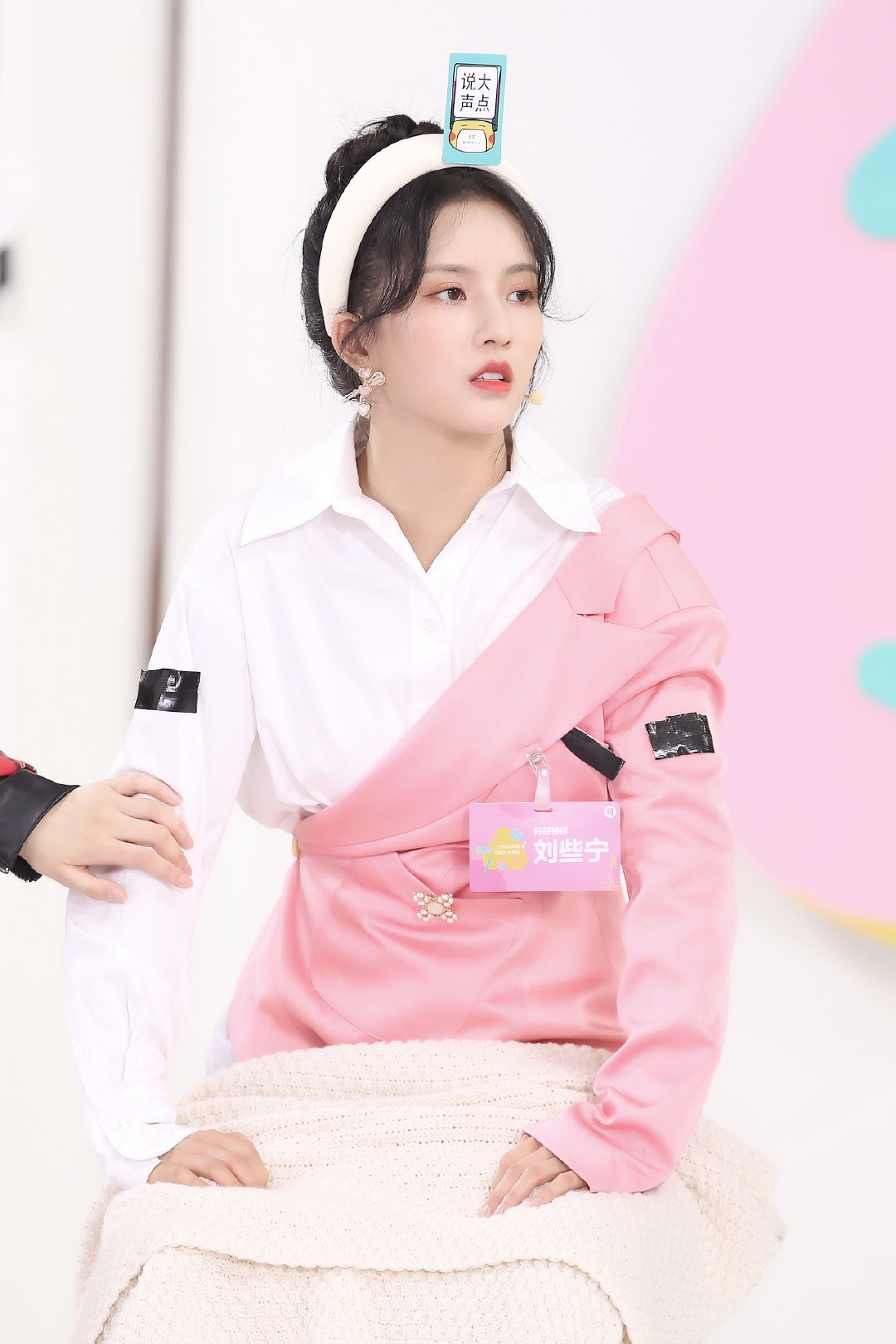 她手捧一束纯白小花低头轻嗅，长长的睫毛在脸颊上投下恬静的阴影