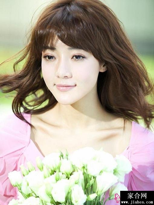 邓家佳身穿优雅长裙立于窗前，柔和光线勾勒出恬淡而知性的气质